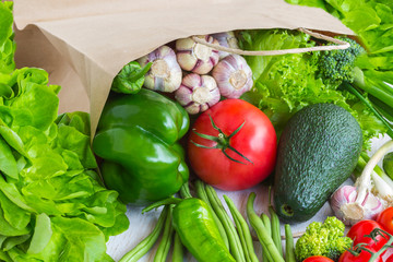 Healthy food in paper bag of different  vegetables on white background. Top view.