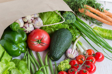 Healthy food in paper bag of different  vegetables on white background. Top view.