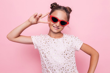 Portrait of a glamorous teenage girl in dark glasses showing two fingers