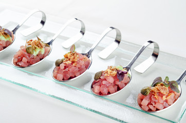 Top view catering banquet table with cold snacks. Raw tuna Tartare decorated capers, close up. Dishes in the restaurant. easy food for guests. Party food.