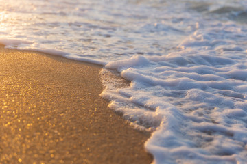 Foam from the sea water on the coast of the beach at sunset day