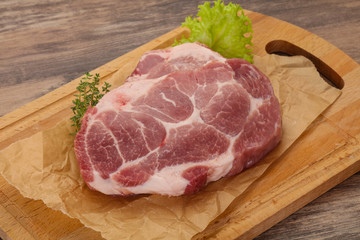 Raw pork steak over wooden board