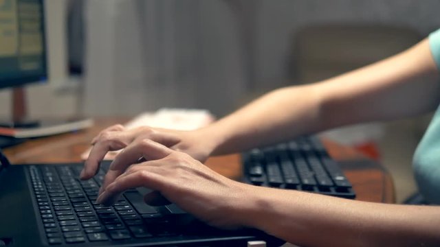 The concept of multitasking or cheating in social networks. One woman types simultaneously on three keyboards. hand closeup.