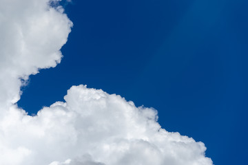 White cumulus clouds against blue sky. Place for text.