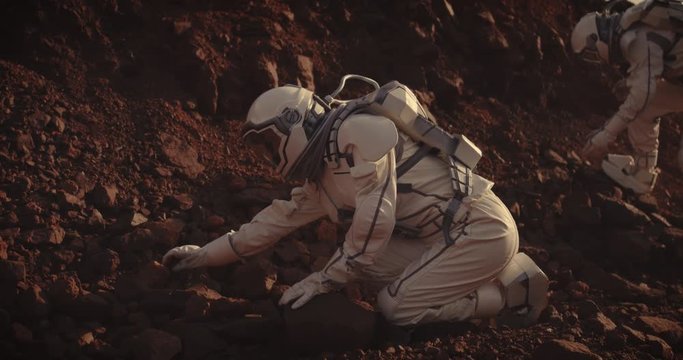 Astronauts collecting rock samples on Mars