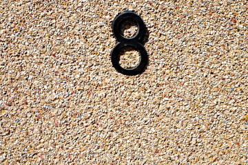 Numeral 8 / eight black on warm tone stone wall.