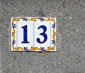 13, number thirteen, decorative tilework on gray surface.