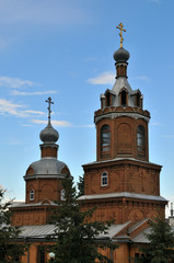 Fototapeta na wymiar Orthodox Christian Cathedral with golden domes and crosses against the sky, spring day. Tserkov' Smch.kharlampiya, Tsivilsk, Russia