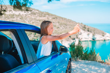 Little girl on vacation travel by car background beautiful landscape