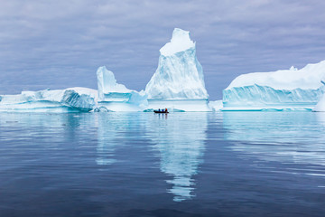 Iceberg graveyard in Antarctica with many huge mass of ice stranded offering spectacular polar landscape for tourists on zodiac boats, frozen continent, Antarctic Peninsula