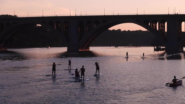 Silhouettes of tourists on paddle boards in Washington, D.C.