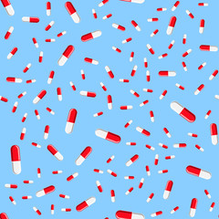 Medical seamless pattern, texture of red and white medicinal oval pharmaceutical beautiful tablets, capsules, vitamins, drugs, antibiotics isolated on a blue background. Concept: health care