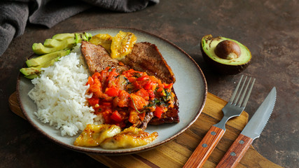 colombian food. El Bistec a la Criolla  -  traditional beef steak with tomatoes sauce, rice, avocado, bananas fries 