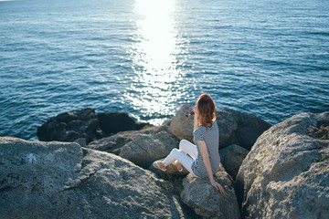 man sitting on a rock and looking at the sea