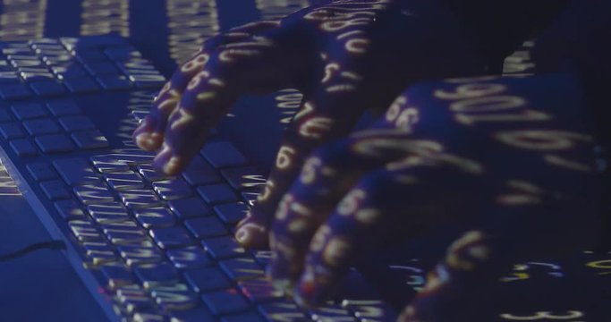 Hands of hacker writes code on the keyboard