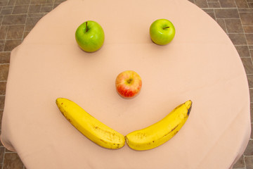 A happy face on the table formed by different fruits. Concept of happiness.