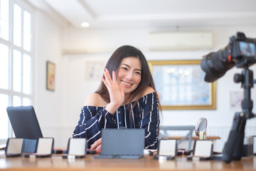 Happy girl blogger at cafe talking about makeup and beauty and recording video tutorial for...