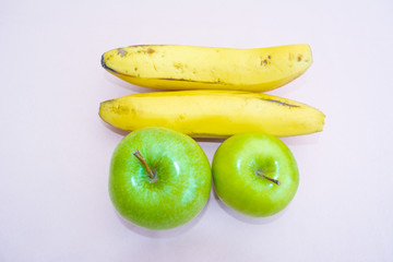 Two bananas next to two green apples with white background