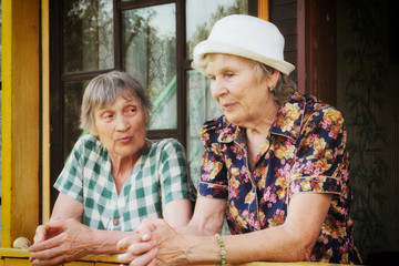 Two elderly women, close friends, have a very important conversation