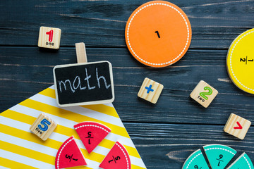 Creative Сolorful math fractions on dark background. Interesting funny math for kids. Education, back to school concept. Geometry and mathematics materials. Flat lay, top view
