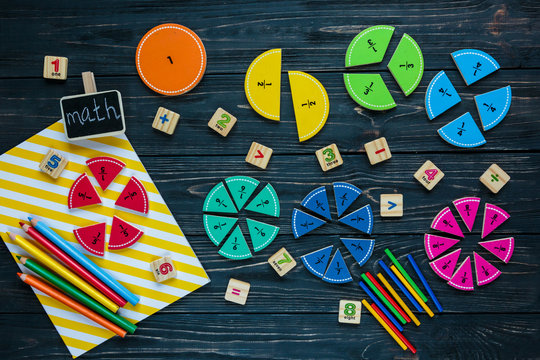 Creative Сolorful math fractions on dark background. Interesting funny math for kids. Education, back to school concept. Geometry and mathematics materials. Flat lay, top view