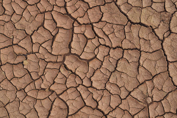 Dry cracked earth during in a rainy season because lack of rain shortage of water cracked soil texture