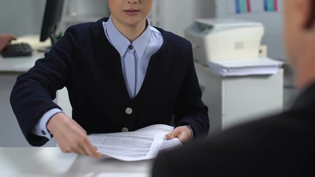 Young woman showing report to financial director, female assistant in office