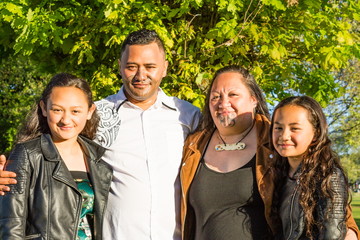 Portrait of a young Maori family taken outdoors