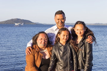 Portrait of a young Maori family taken outdoors - obrazy, fototapety, plakaty