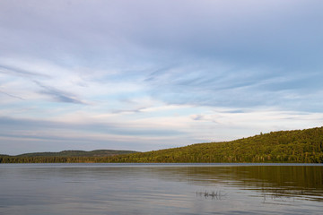 beautiful violet sky over glassy water of Lake of Two Rivers in Algonquin Park at twilight