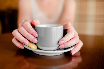 Female hands hold hot grey  coffee cup beverage, drinks cappuccino. Horizontal several objects copyspace
