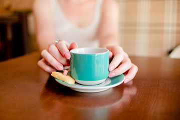 Female hands hold hot green  coffee cup beverage, drinks cappuccino. Horizontal several objects copyspace