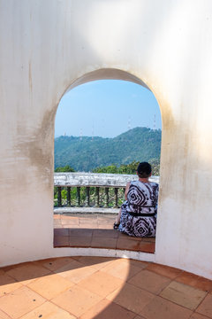 The tourist woman sitting at Khao Wang palance or Phra Nakhon Khiri Historical Park in Phetchaburi provine, Thailand.