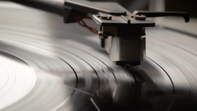 Dropping Stylus Needle On Vinyl Record Playing With Disc Rotating Close Up. Old dusty turntable.