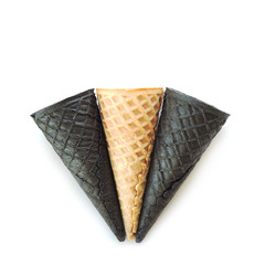 One beige and two black empty ice cream cones. Isolate on white background..