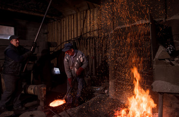 blacksmith workers using mechanical hammer at workshop