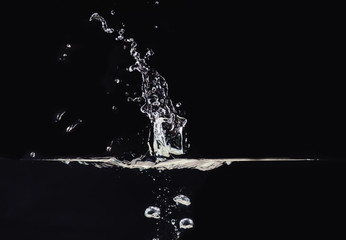Explosion on water surface isolated on black background, close up view. Water bubbles underwater...