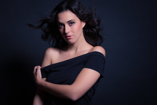 Chica con blusa negra en estudio retrato sentimiento posando