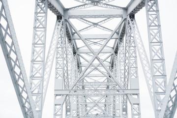Metal steel railway bridge. Connecting structure over the railway. Metallic connecting beams intersecting form an arch over railroad tracks