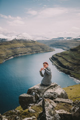 Fototapeta na wymiar Traveler shows heart in front of cliffs Faroe islands