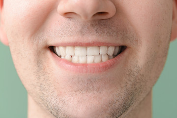 Fototapeta premium Man with healthy teeth on color background, closeup