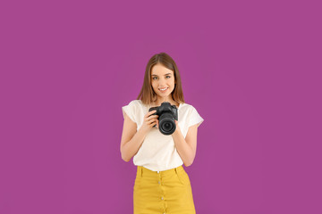 Obraz premium Young female photographer on color background