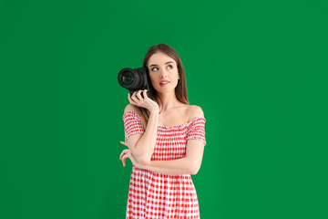 Obraz premium Young female photographer on color background