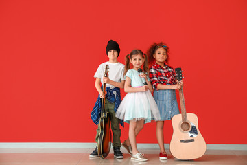 Band of little musicians against color wall