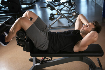 Sporty young man training in gym