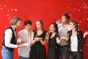 Group of friends celebrating Birthday on color background