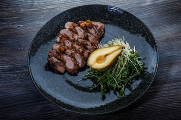 delicious grilled beef meat slices with half of baked pear