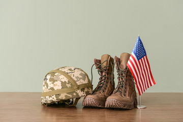 Military helmet, boots and USA flag on table