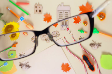 Look through glasses, stationery or school supplies. Selective focus in the foreground. Back to school concept. Copy space, top view, flat lay.