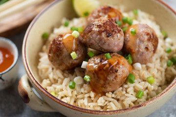 Close-up of roasted pork meatballs and rice in a bowl, selective focus